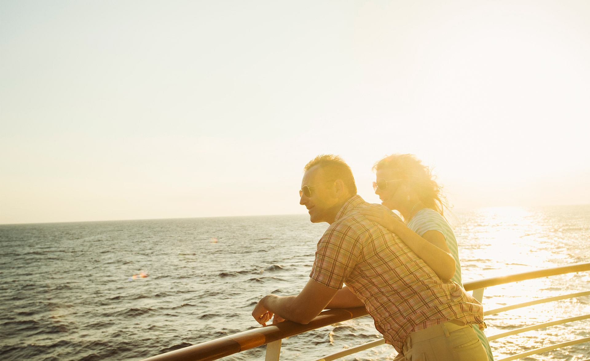 A couple - woman and man - at the railing of a luxury cruise ship