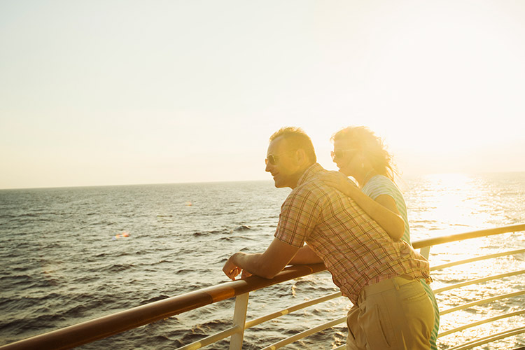 A couple - woman and man - at the railing of a luxury cruise ship