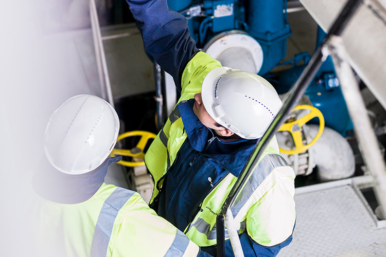 Two engineers at Consilium discussing the installation of a fire detector