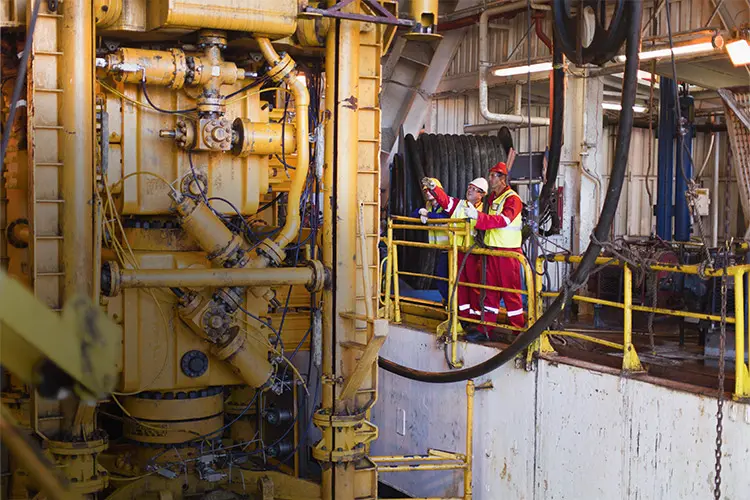 Technicians on an oil rig out at sea, perform service work