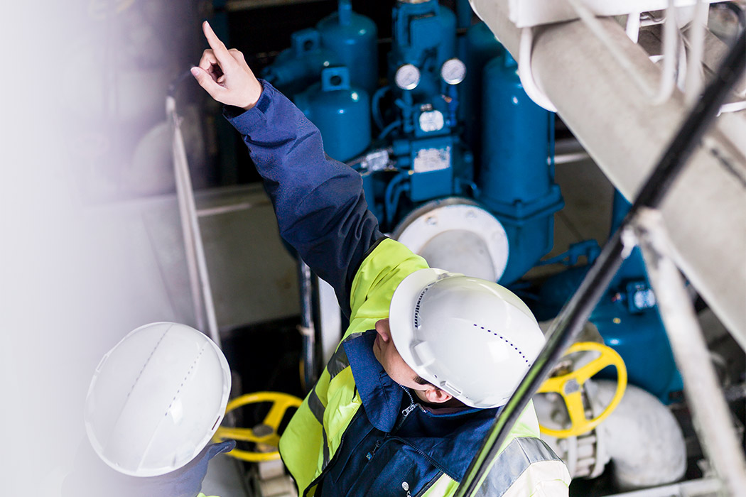 Two engineers at Consilium discussing the installation of a fire detector