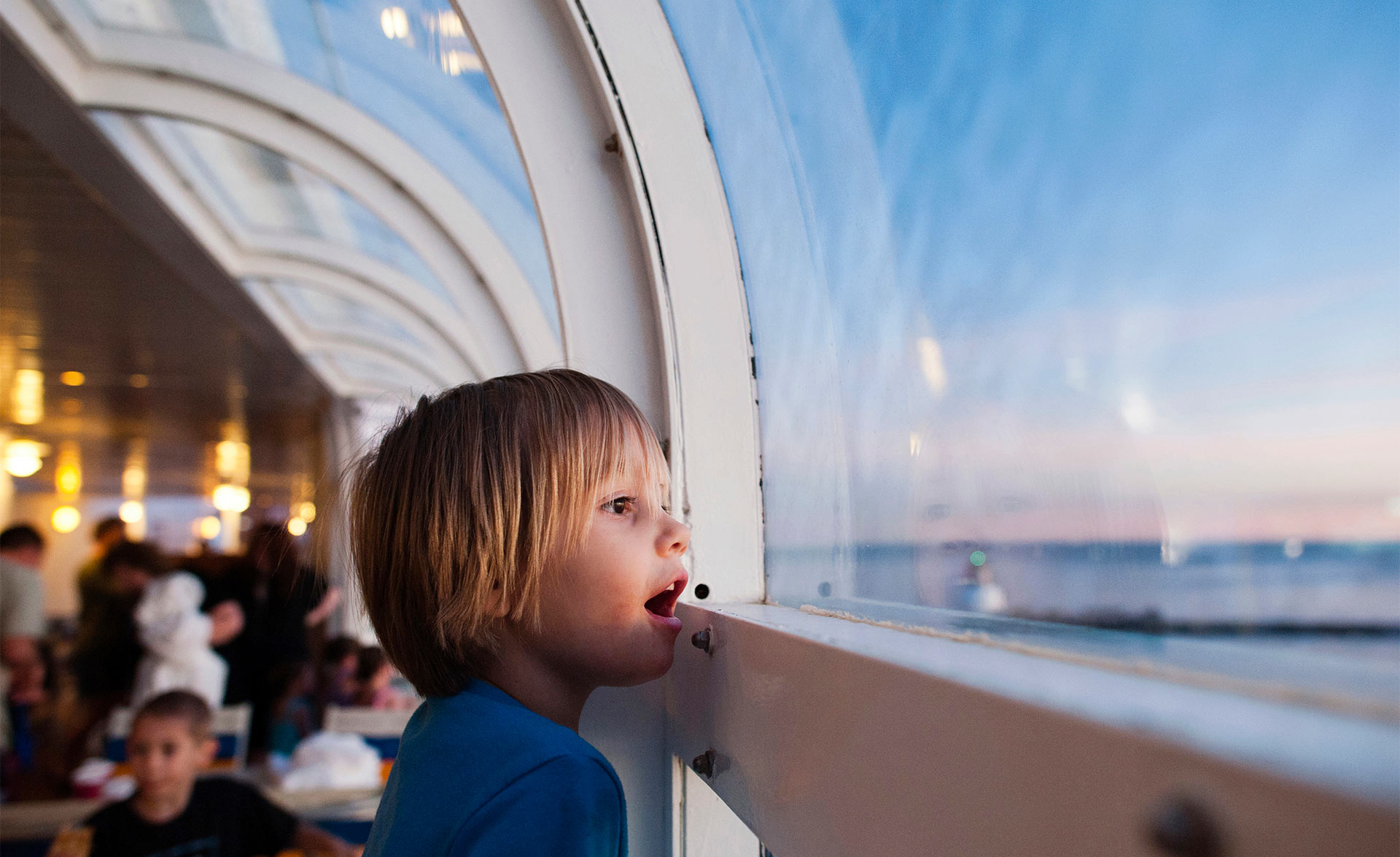 A boy on a cruise ship looking out the window